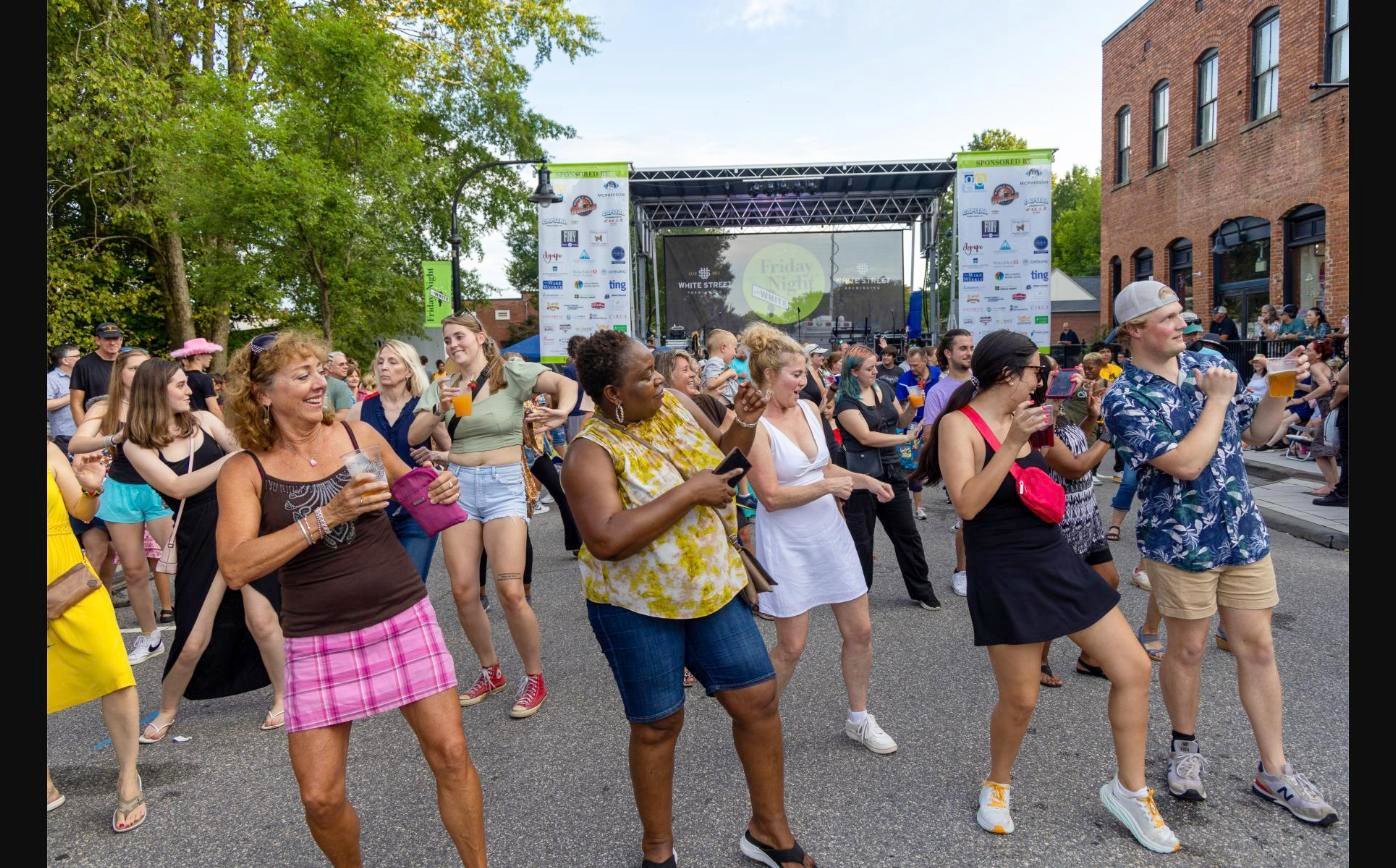 Crowd dancing in front of the Friday Night on White stage in downtown Wake Forest, NC